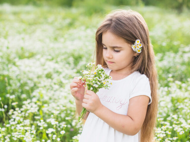 dziewczynka patrząca na kwiaty